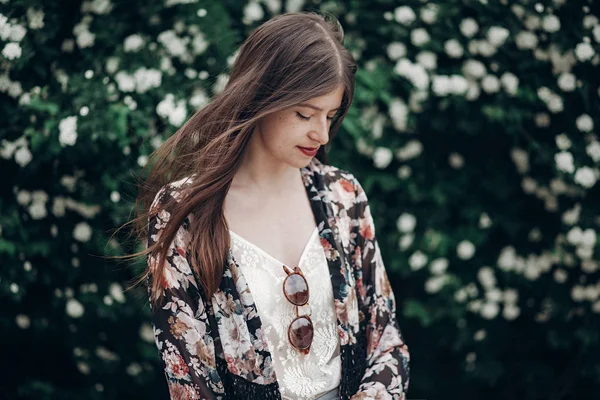 Chica posando sobre fondo de florecimiento arbusto — Foto de Stock