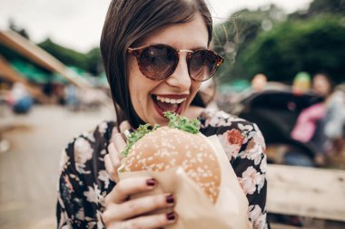 hamburger ısırma güneş gözlüklü kız