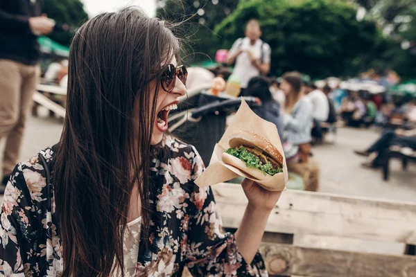 Chica en gafas de sol comer hamburguesa — Foto de Stock