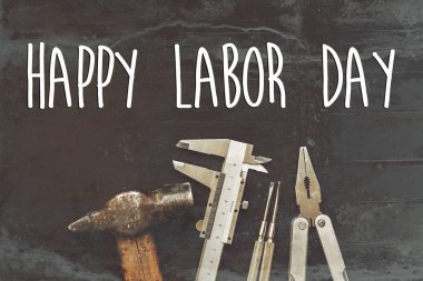 mutlu İşçi Bayramı metin işareti. Siyah arka plan üzerine çalışma araçları