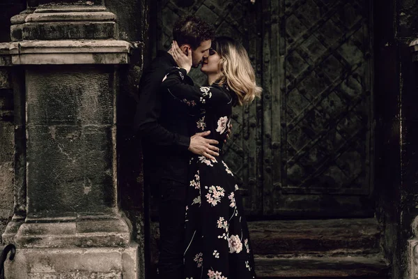 Casal beijando perto de portão de metal — Fotografia de Stock