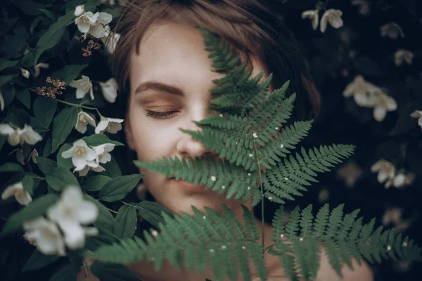 Femme couvrant le visage avec des feuilles — Photo