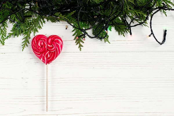 Corazón caramelo piruleta y guirnalda de Navidad —  Fotos de Stock