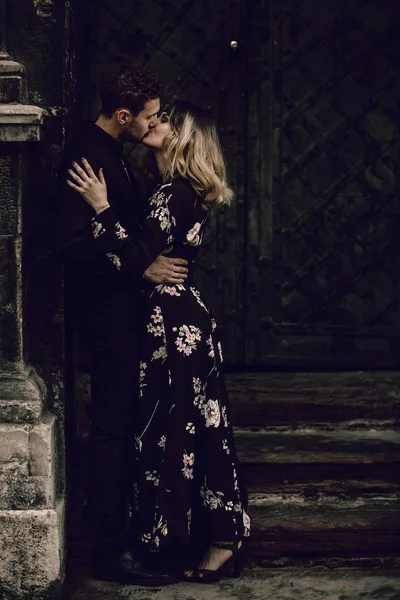 Casal beijando perto de portão de metal — Fotografia de Stock