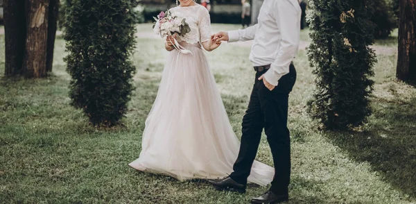 Наречений і наречений тримаються за руки — стокове фото