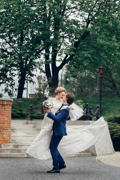 Bräutigam hebt schöne Braut hoch — Stockfoto