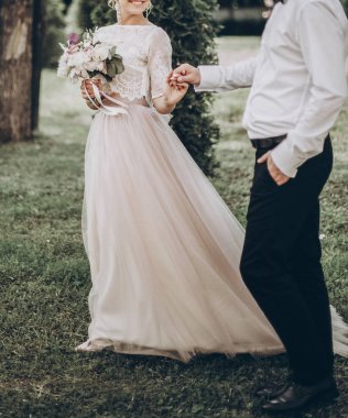 Gelin ve damat el ele tutuşuyorlar.