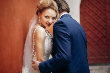 Yeni evli çift duvara yakın poz 