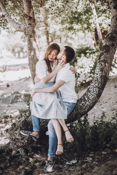 Pareja sentada en árbol en parque —  Fotos de Stock