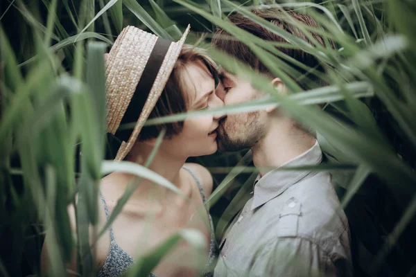 Par embracing vid sjön i sockerrör — Stockfoto