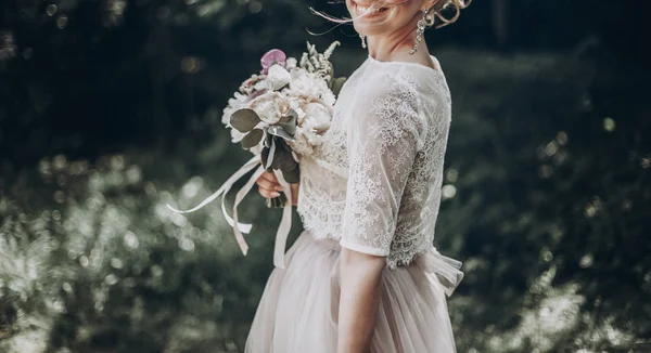 Bruden med bukett tittar på brudgummen — Stockfoto