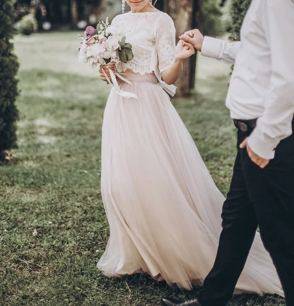 Brud- och brudgummen håller varandra i handen — Stockfoto