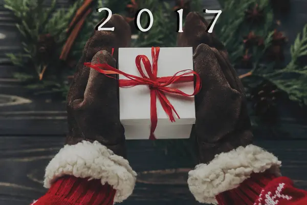 Manos en guantes sosteniendo regalo de Navidad — Foto de Stock