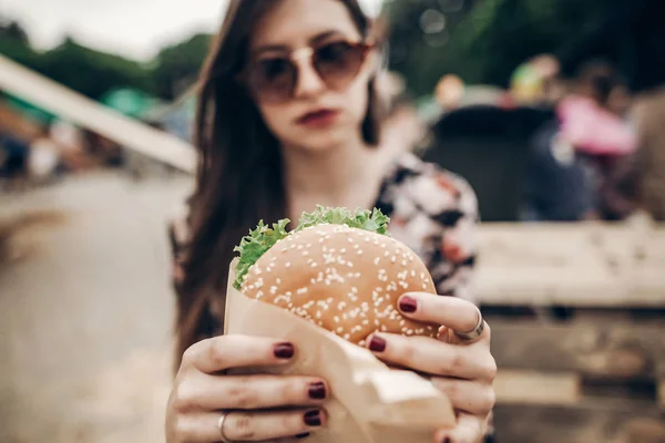 Chica en gafas de sol celebración de hamburguesa — Foto de Stock