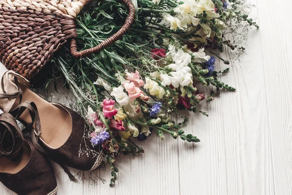 Hermosas flores silvestres y zapatos femeninos — Foto de Stock