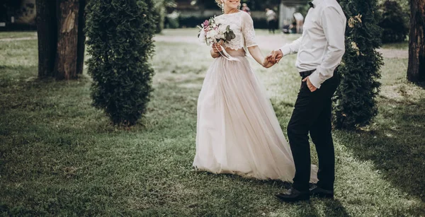 Braut und Bräutigam halten Händchen — Stockfoto