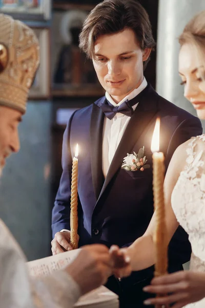 Невеста и жених держат свечи — стоковое фото