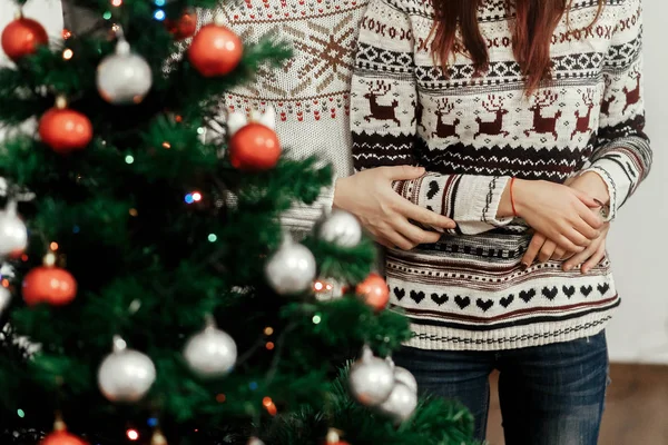 Пара обнимается возле рождественской елки — стоковое фото