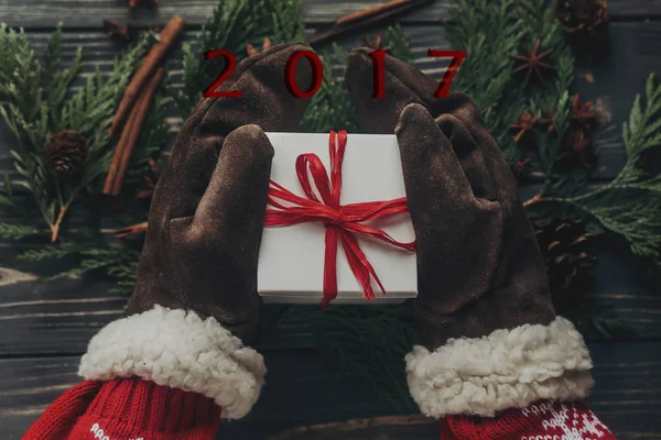 Handen in handschoenen houden kerstcadeau — Stockfoto