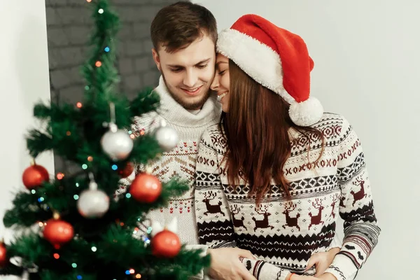 Pareja abrazándose en árbol de Navidad — Foto de Stock