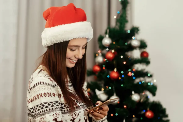 Lány a Santa kalap telefonnal — Stock Fotó
