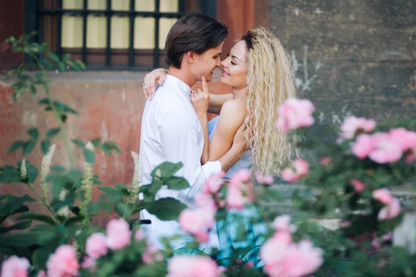 Casal perto de flores rosa — Fotografia de Stock