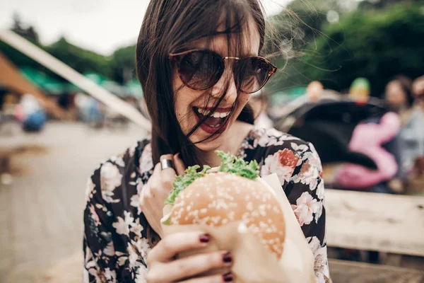 Девушка держит гамбургер в руках — стоковое фото
