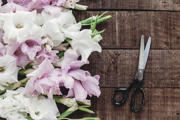 Ножницы и розовые и белые гладиолусы — стоковое фото
