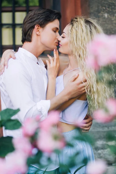 Casal perto de flores rosa — Fotografia de Stock