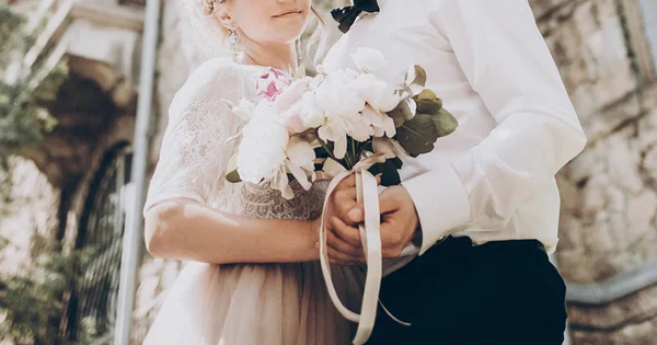 Bruden och brudgummen håller bukett — Stockfoto