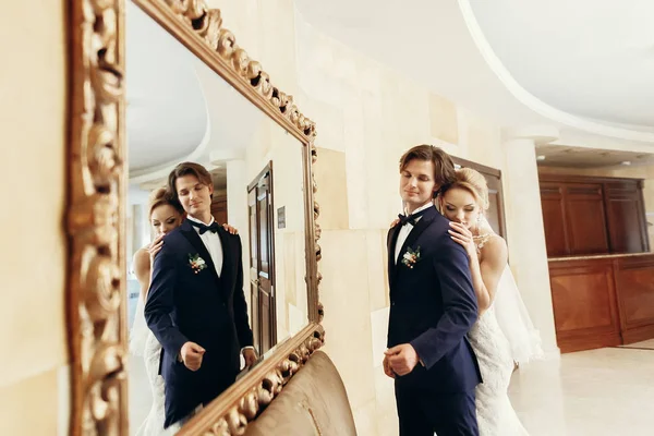 Bruden kramas brudgummen inomhus — Stockfoto