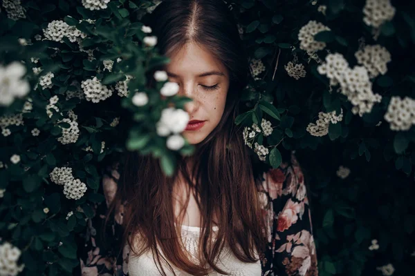 Woman in blooming bush with — Stock Photo, Image