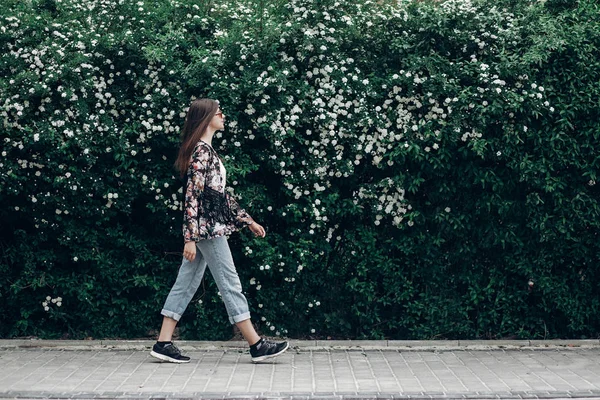 Девушка ходит по фону куста — стоковое фото
