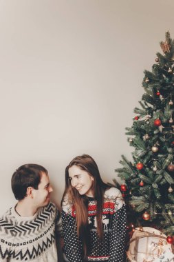 şık hipster kaç sarılma ve Noel ağacının rahat akşam odada kucaklayan kazak içinde.