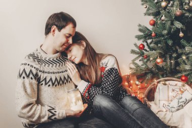 mutlu çift fener ışık tutan ve yavaşça sarılma şık kazak