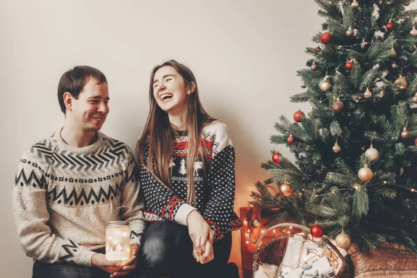 笑って押しランタン光のクリスマス ツリーに座って楽しんで幸せなカップル — ストック写真