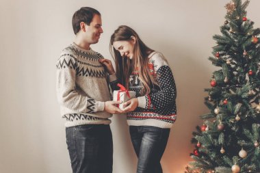 Genç çift hediyeler Noel ağacı ışıkları ile yakın duran alışverişi