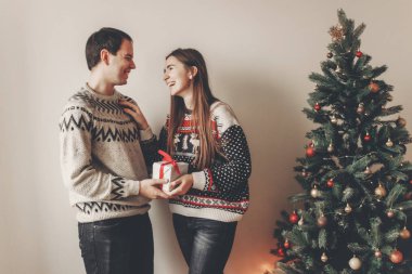 Genç çift hediyeler Noel ağacı ışıkları ile yakın duran alışverişi