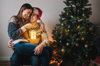 şık iki kazak Noel ağacı oturan ışık ile fener tutarak sonra 