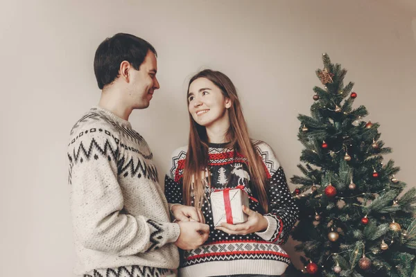 Junges Paar Tauscht Geschenke Aus Die Neben Dem Weihnachtsbaum Mit — Stockfoto