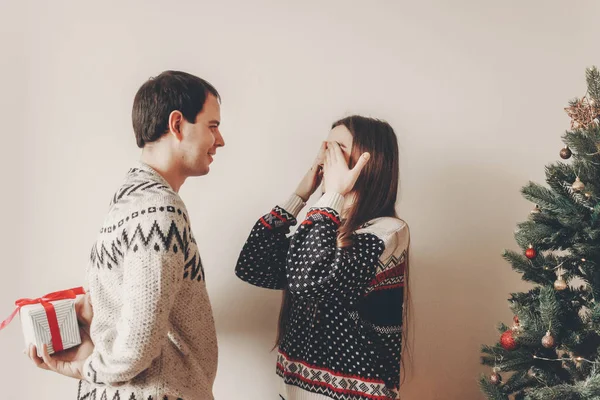 幸せな若い男彼のクリスマス ツリーの近くの女性に与えるプレゼント — ストック写真