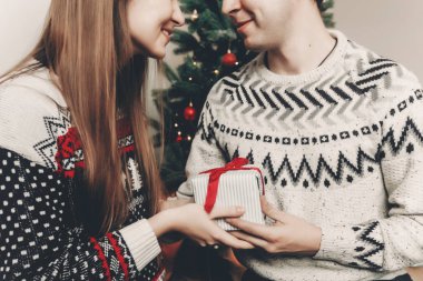 Genç çift, yılbaşı ağacı, hediye kutusu tutarak kırpma 