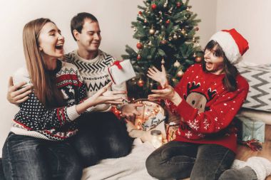 mutlu arkadaş şık kazak ve hediyeler Noel ağacı ışıkları ile oturan alışverişi şirin komik köpek