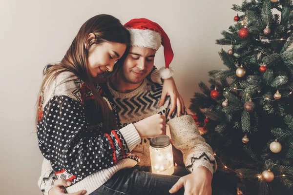 Elegante Pareja Suéteres Con Linterna Con Luz Sentada Árbol Navidad — Foto de Stock