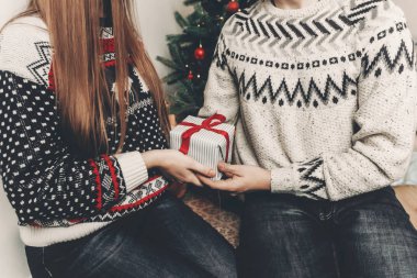 mutlu aile içinde şık kazak hediyeler Noel ağacı ve ışıklar ile festival odasında alışverişi. 