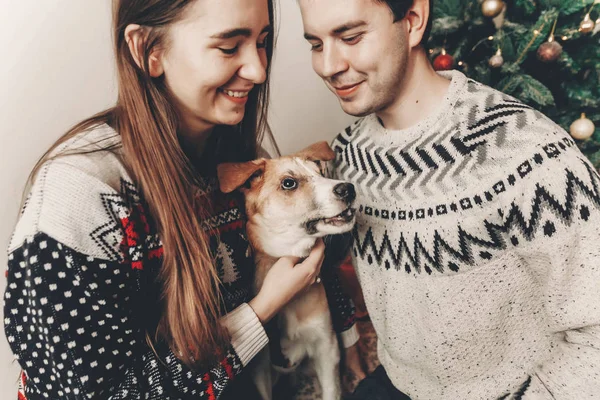 Elegante Pareja Hipster Suéteres Abrazando Perro Sonriendo Posig Árbol Navidad — Foto de Stock