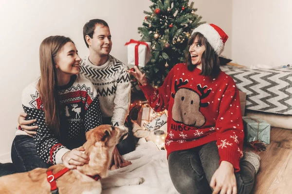 Amigos Suéteres Festivos Arrojando Regalos Sentados Árbol Navidad Decorado — Foto de Stock