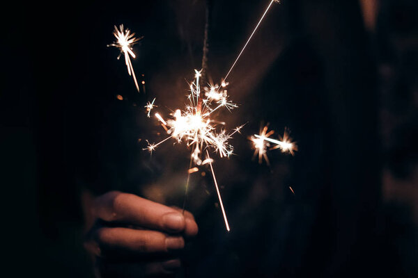 Рука держит горящий рождественский фейерверк бенгальский свет. пространство для текста
.