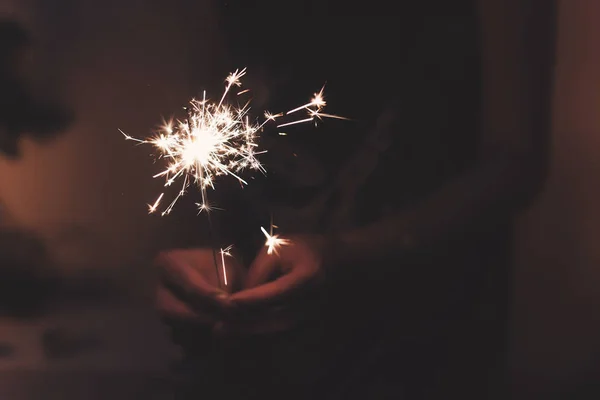 Mano sosteniendo una luz de bengala chispeante ardiente — Foto de Stock