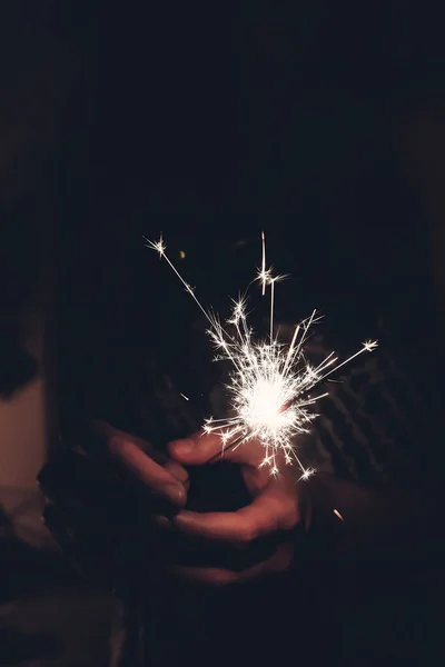 Mão segurando uma queima faísca fogos de artifício bengala luz . — Fotografia de Stock